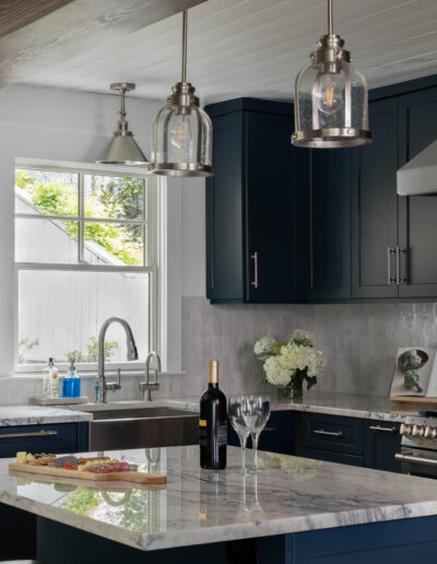 Focused view of island with pendant lighting and marble surfaces.